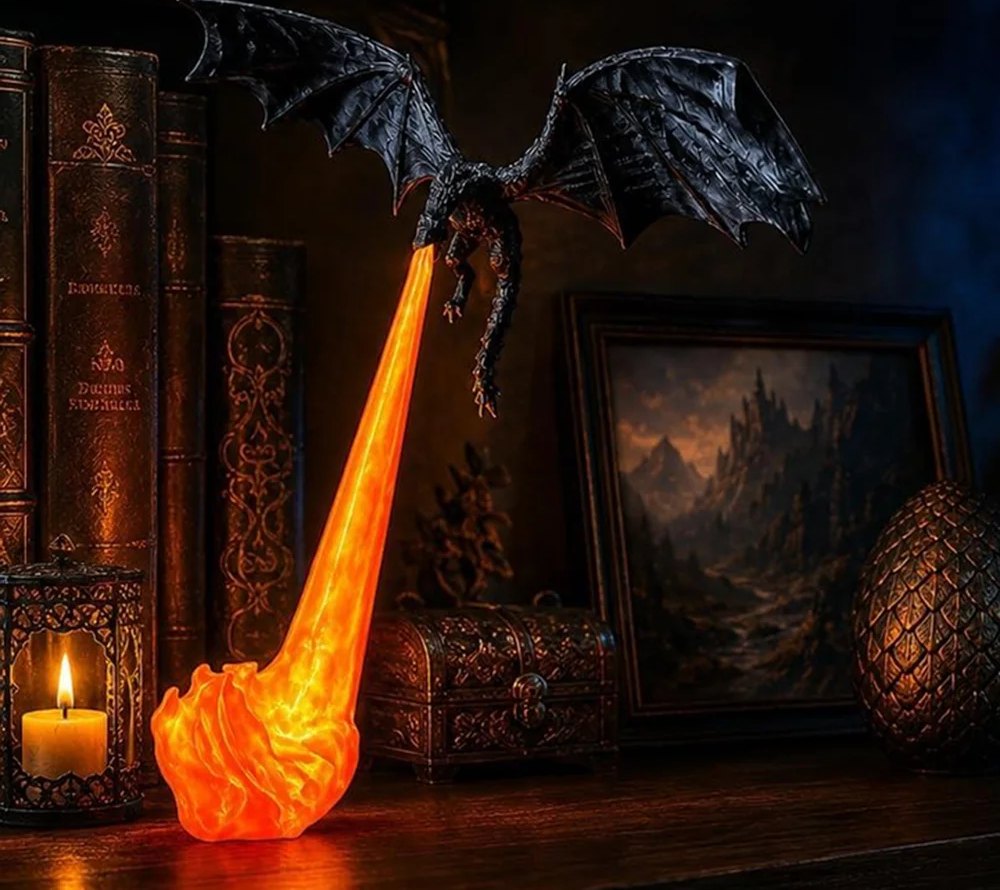 Domavius™ Drakorya — lampe dragon posée devant des livres, flamme orange allumée